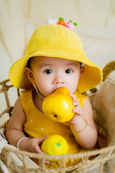 Imagen de un bebé en una cesta comiendo fruta por el método baby-led weaning